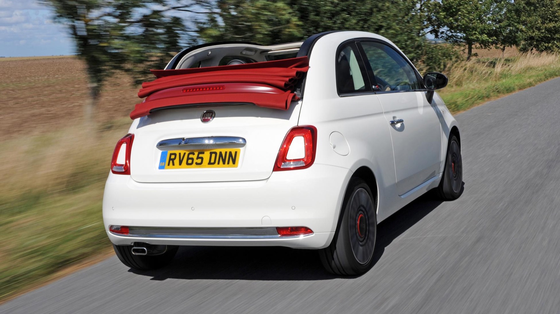 White Fiat 500C driving on a country road